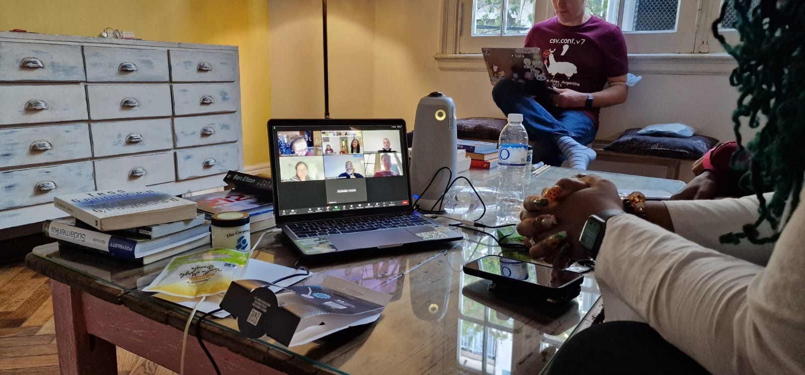 Executive Council member viewing an open laptop with virtual Executive Council members shown on the screen. Next to the laptop sits the Meeting Owl